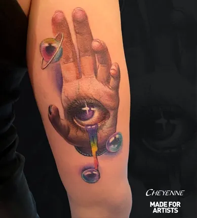 Hand mit Auge und Planeten als Farbtattoo