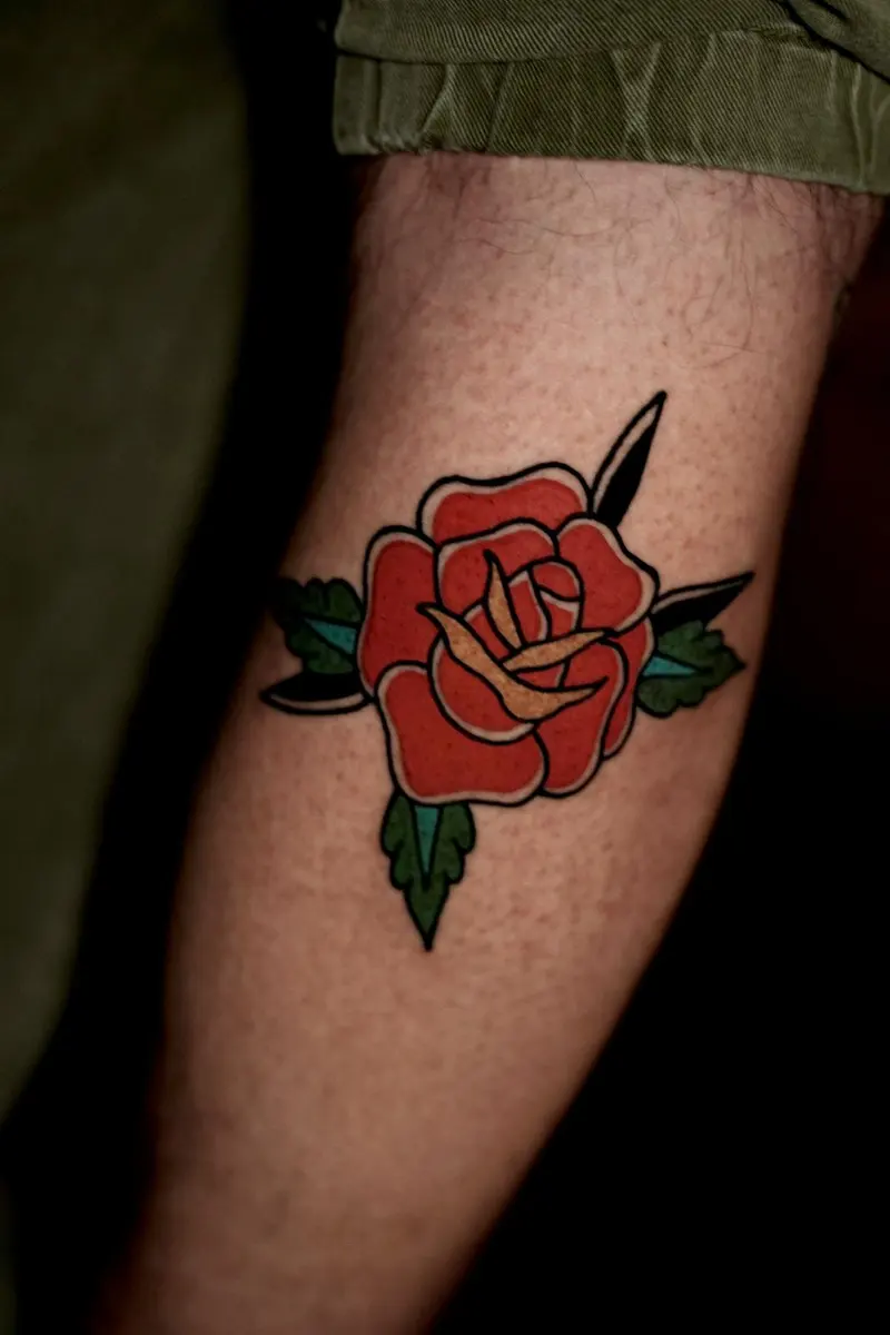 Rote Rose mit Blättern, Old-School-Tattoo am Unterarm