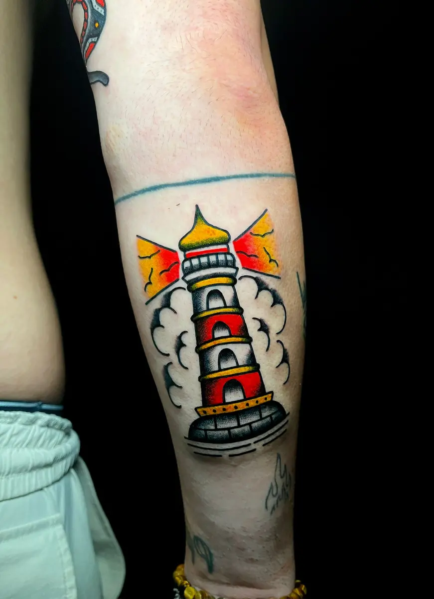 Leuchtturm mit Wolken, Old-School-Tattoo am Unterarm