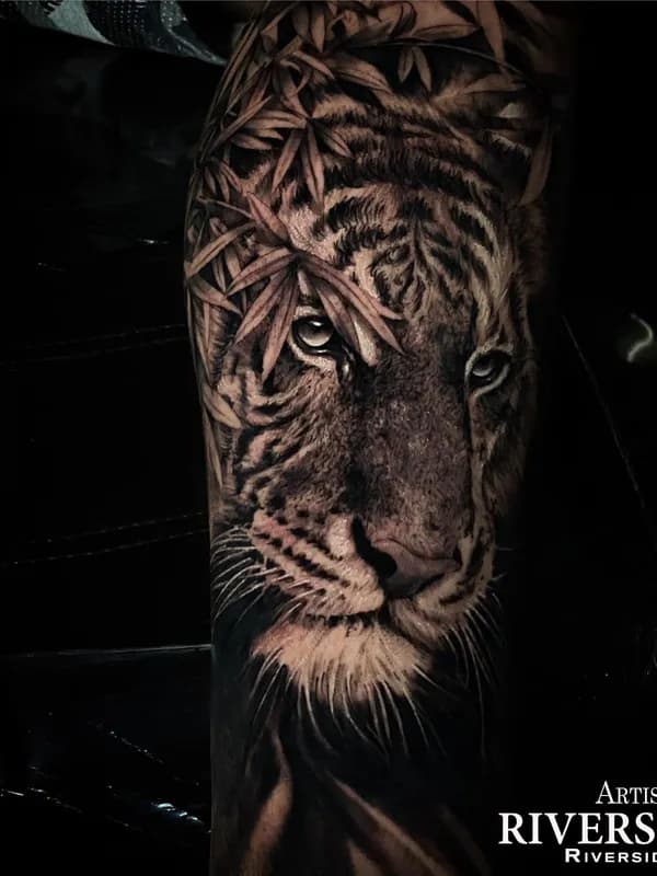 Tigerkopf mit Bambusblättern, Black-and-Grey-Realistic-Tattoo auf dem Oberarm