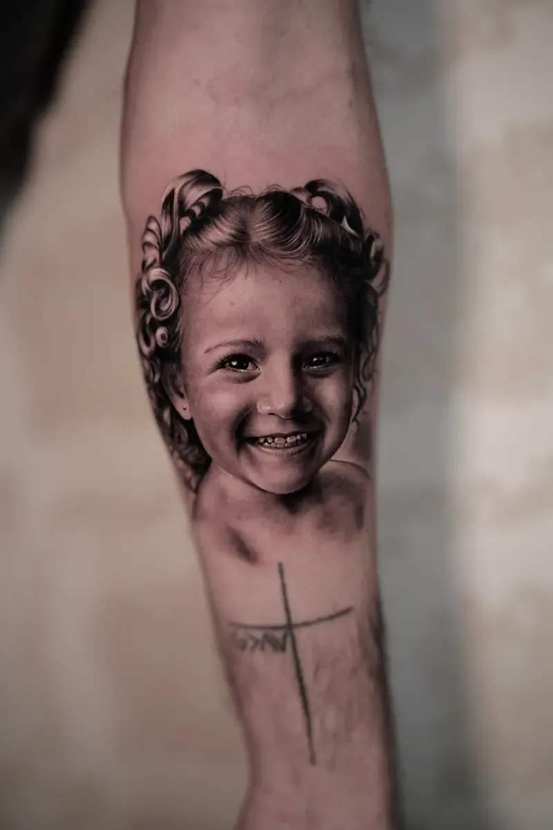 Porträt eines lächelnden Mädchens, Black-and-Grey-Realistic-Tattoo auf dem Unterarm – Arbeit von Guilherme, Riverside Ink St. Margrethen
