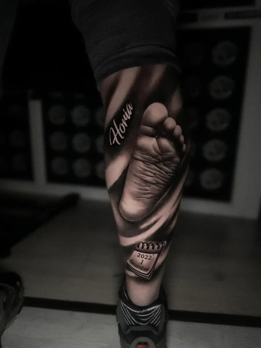 Fussabdruck mit Namen und Datum, Black-and-Grey-Realistic-Tattoo am Unterschenkel – Arbeit von Vasy, Riverside Ink St. Margrethen