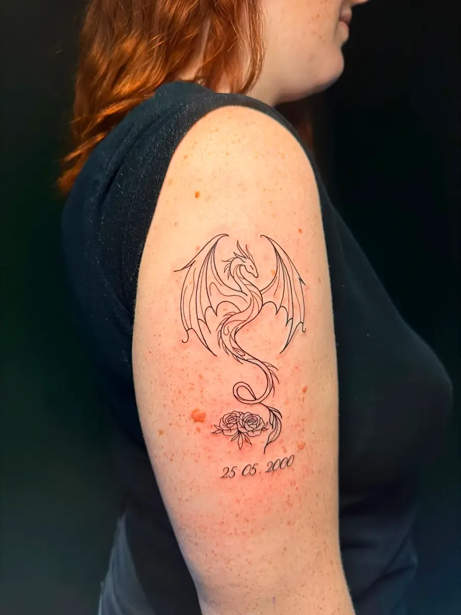 Fineline-Drache mit Rosen und Datum am Oberarm – Arbeit von Arlenys, Riverside Ink St. Margrethen