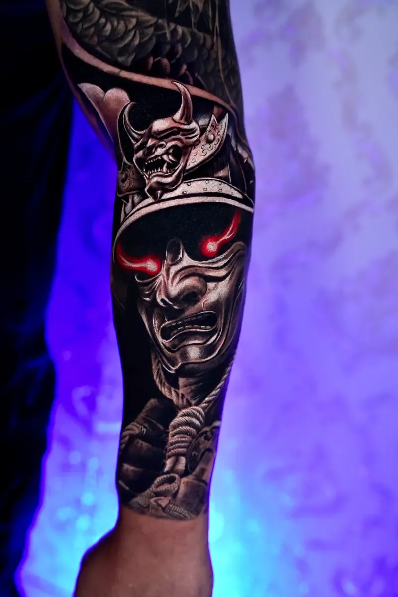 Samurai-Maske mit roten Augen, Black-and-Grey-Realistic-Tattoo auf dem Unterarm – Arbeit von Guilherme, Riverside Ink St. Margrethen