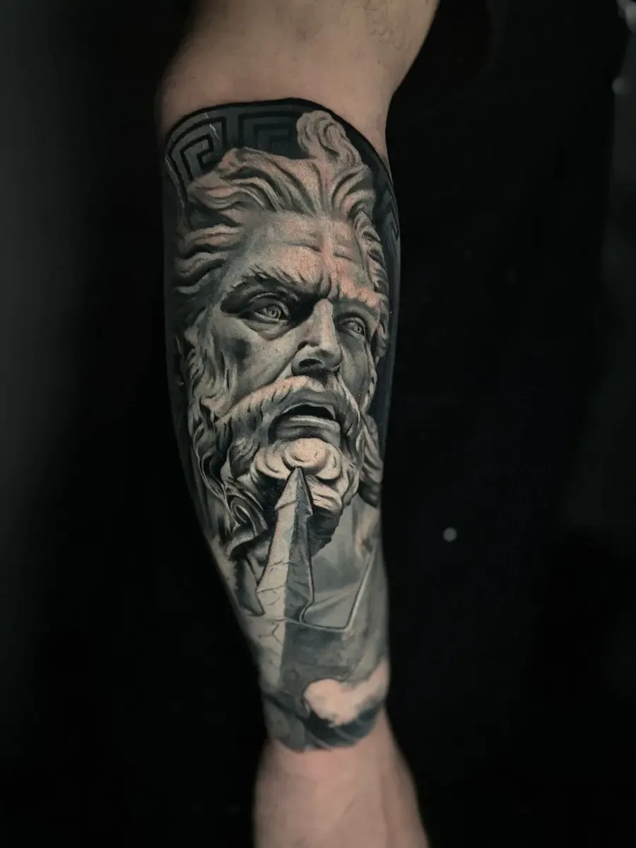 Zeus-Kopf als Statue, Black-and-Grey-Realistic-Tattoo auf dem Unterarm – Arbeit von Marco Carbonaro, Riverside Ink St. Margrethen