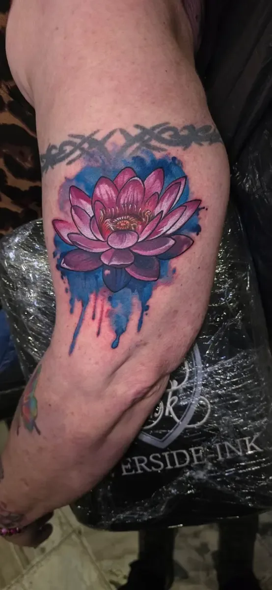 Pinke Lotusblüte mit Farbverlauf, Aquarell-Tattoo am Arm – Arbeit von Zule, Riverside Ink St. Margrethen