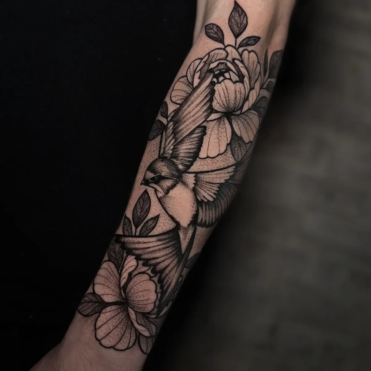 Schwalben mit Pfingstrosen, Blackwork-Tattoo auf dem Unterarm – Arbeit von Carlos Moreno, Riverside Ink St. Margrethen