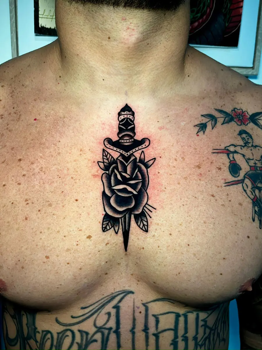 Dolch mit Rose, Blackwork-Tattoo auf der Brust